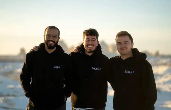 Three Tapped teammates in the snow, wearing company hoodies